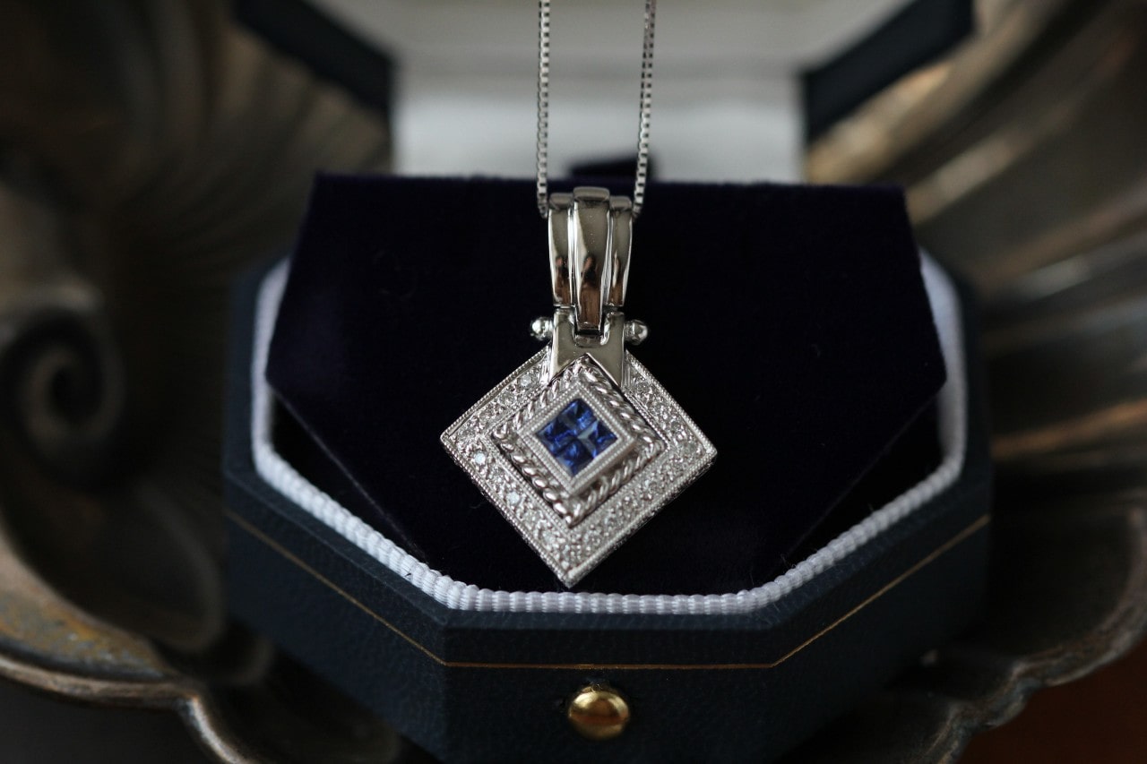 a white gold and sapphire pendant necklace in a luxurious box