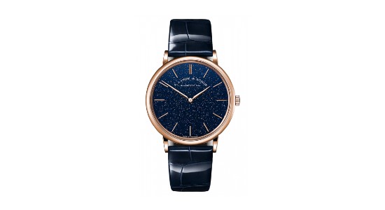 a rose gold watch with a deep blue dial and strap