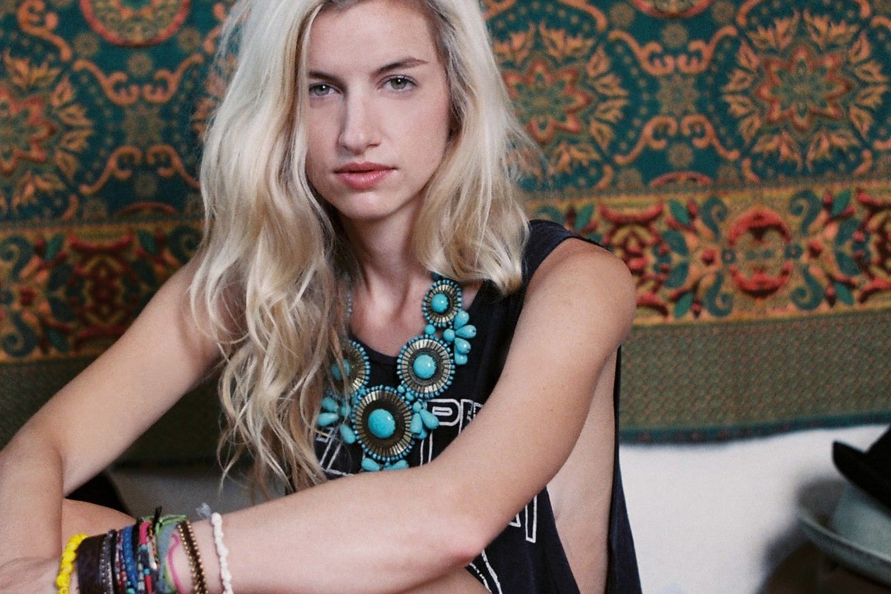 a woman poses while wearing a dramatic turquoise necklace.