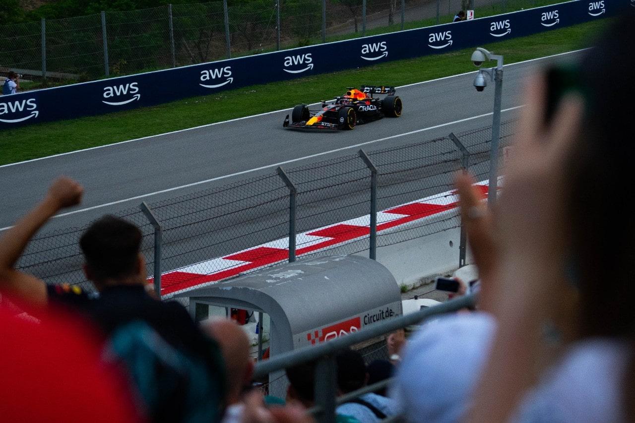 a Formula 1 car and fans cheering in the crowd