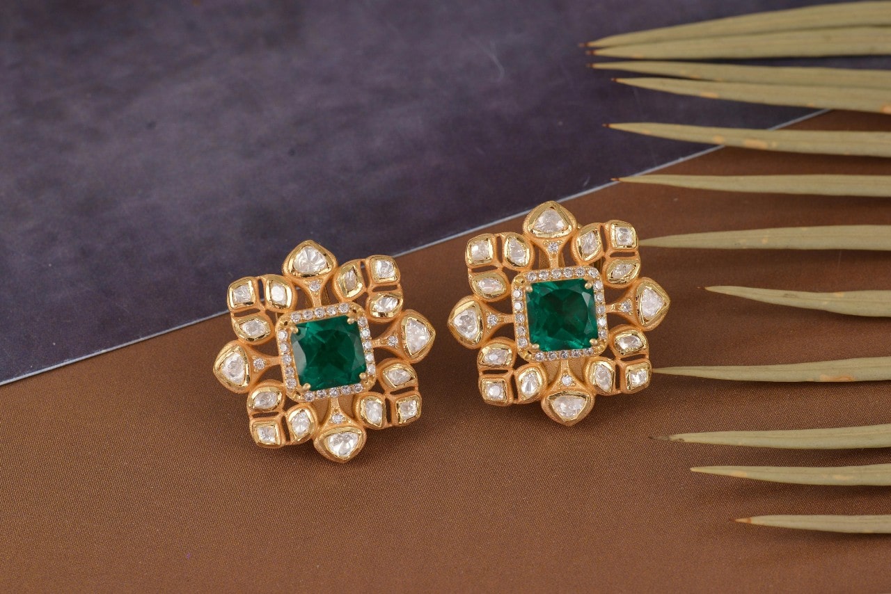 a pair of yellow gold, diamond, and emerald stud earrings