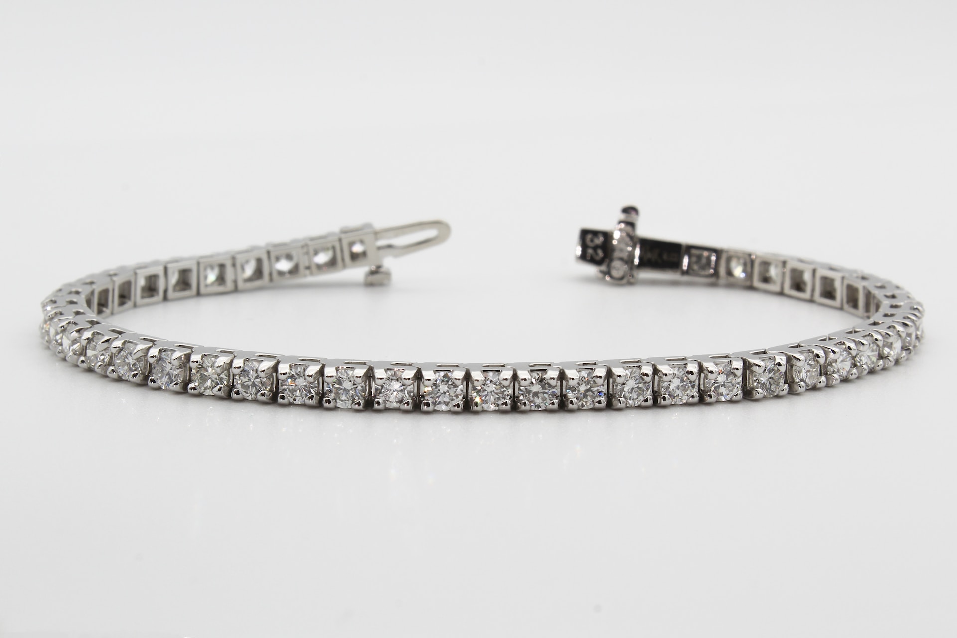 a white gold diamond tennis bracelet against a white background